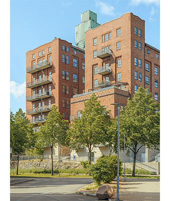 Hasselblad X1D Sample Image of red brick buildings in the foreground with green trees and clear blue sky